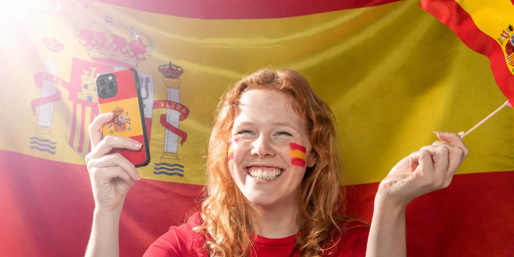 Aficionada de España con móvil y funda personalizada con bandera española para vivir un partido del Mundial 2026